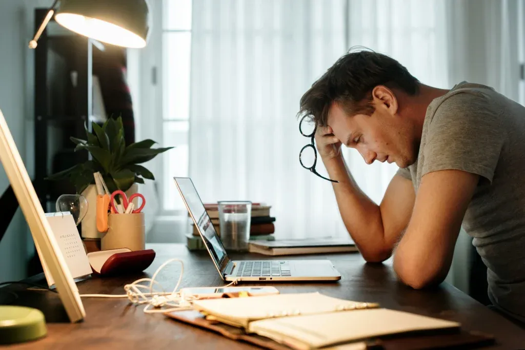 Jeune adulte stressé devant son ordinateur en pleine surcharge de travail