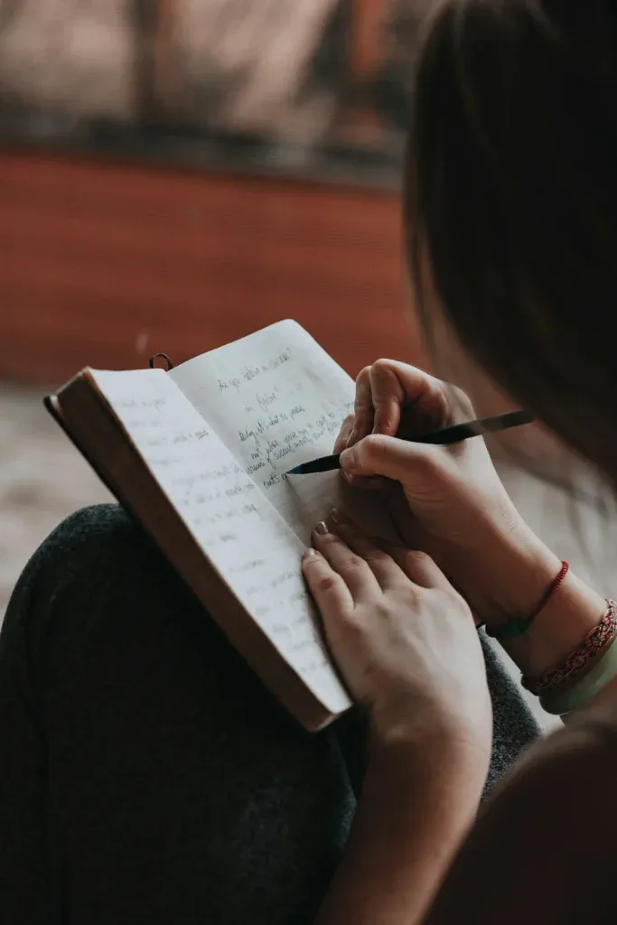 Person writing in a notebook to document a difficult situation