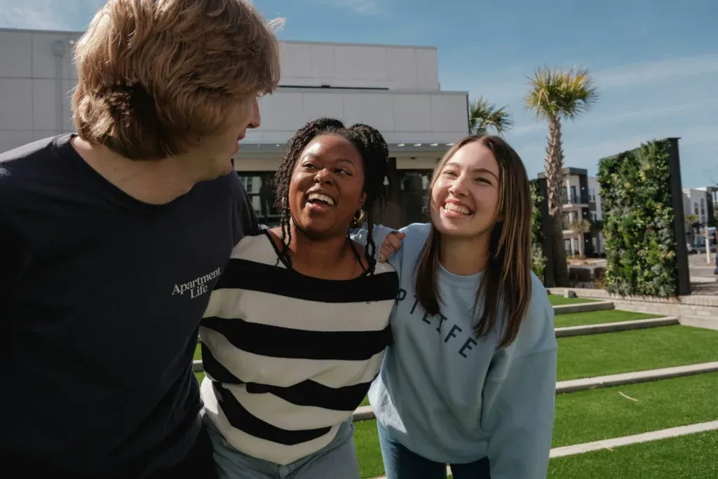 Group of young adults laughing together outdoors in the afternoon