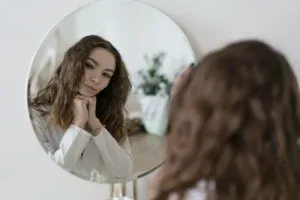 Adolescente pensive qui regarde son reflet dans un miroir